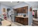 Well-organized kitchen with dark wood cabinets, stainless steel fridge, and an open view to the laundry room at 16705 Rolling Green Dr, Clermont, FL 34714