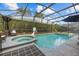 Relaxing pool and spa with a screened enclosure and lush green landscaping at 16705 Rolling Green Dr, Clermont, FL 34714