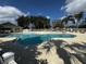 A spacious community pool surrounded by plenty of chairs and shady trees at 16705 Rolling Green Dr, Clermont, FL 34714