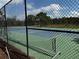 Outdoor tennis court with a green and blue surface surrounded by a black fence at 16705 Rolling Green Dr, Clermont, FL 34714