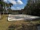 Outdoor sand volleyball court on a sunny day is surrounded by green grass and trees at 16705 Rolling Green Dr, Clermont, FL 34714