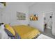 Bedroom with a yellow bed, tiled floors, and TV, leads into the ensuite bathroom at 16726 Hidden Spring Dr, Clermont, FL 34714