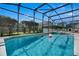 Relax in this screened-in backyard oasis featuring a private pool, spa, and outdoor seating area at 16726 Hidden Spring Dr, Clermont, FL 34714