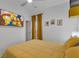 Cheery bedroom featuring yellow bedding, natural light, and a television showing The Simpsons at 16739 Hidden Spring Dr, Clermont, FL 34714