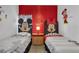 Charming bedroom featuring two twin beds with playful Mickey Mouse-themed headboards and bright red accent wall at 16739 Hidden Spring Dr, Clermont, FL 34714