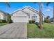 Charming home featuring a two-car garage, well-maintained lawn and mature landscaping at 16739 Hidden Spring Dr, Clermont, FL 34714