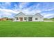 Inviting single-story home features a light gray exterior, covered porch, and a sprawling green lawn at 1679 E County Road 462, Wildwood, FL 34785