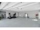 Spacious garage with epoxy floor, providing ample room for storage and hobbies, enhanced by bright lighting at 1679 E County Road 462, Wildwood, FL 34785