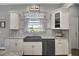 Modern kitchen with granite countertops, gray backsplash, stainless steel appliances, and a farmhouse sink at 1679 E County Road 462, Wildwood, FL 34785