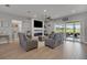 Inviting living room with modern fireplace, mounted TV, and sliding doors to the outdoor patio at 1679 E County Road 462, Wildwood, FL 34785