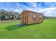 A wooden shed, with ramps, sits on a well-manicured lawn at 1679 E County Road 462, Wildwood, FL 34785