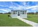 A small shed with a stone pathway is on a large green lawn at 1679 E County Road 462, Wildwood, FL 34785