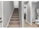 Carpeted staircase leading to the upper level, near a laundry room and powder room at 1679 E County Road 462, Wildwood, FL 34785