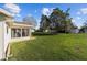 Lush green backyard with the screened in porch and home in the background at 17813 Se 95Th Ct, Summerfield, FL 34491