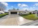 Inviting single-story home features a screened garage, extended driveway, manicured lawn and covered porch seating at 17813 Se 95Th Ct, Summerfield, FL 34491