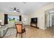 Bright living room with tan tile floors, neutral walls, a ceiling fan and comfortable seating near a front door at 17813 Se 95Th Ct, Summerfield, FL 34491