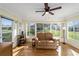 Bright sunroom with ceiling fan and view of the backyard at 17813 Se 95Th Ct, Summerfield, FL 34491