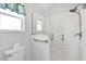 Contemporary bathroom with a glass-enclosed shower, grab bar, and toilet at 17979 Se 89Th Rothway Ct, The Villages, FL 32162