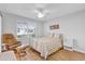 Cozy bedroom with a ceiling fan, a comfortable chair, and natural light at 17979 Se 89Th Rothway Ct, The Villages, FL 32162