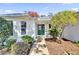 Charming home's entryway with a green door, stone pathway, and lush landscaping at 17979 Se 89Th Rothway Ct, The Villages, FL 32162