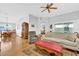 Bright living room with hardwood floors, ceiling fan, and comfortable seating, adjacent to the dining area at 17979 Se 89Th Rothway Ct, The Villages, FL 32162