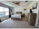 Spacious main bedroom featuring a ceiling fan, dresser, and a large window at 1799 Post Oak Dr, Davenport, FL 33837