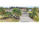 Aerial view of a charming home featuring lush landscaping, a well-maintained lawn, and a spacious three-car garage at 2059 Landings Ln, The Villages, FL 32162