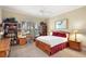 Cozy bedroom featuring a ceiling fan, large window, and wood furnishings with a red accents at 2059 Landings Ln, The Villages, FL 32162