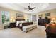 Cozy main bedroom with a tray ceiling, a king-size bed, and dresser at 2059 Landings Ln, The Villages, FL 32162