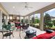 Covered patio with outdoor kitchen, ceiling fans and elegant black wicker furniture with red cushions at 2059 Landings Ln, The Villages, FL 32162