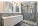 Modern bathroom featuring double vanity, marble walls, and glass-enclosed shower at 210 Palermo Pl, Lady Lake, FL 32159