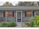 Inviting screened front porch with brick foundation and decorative black shutters at 210 Palermo Pl, Lady Lake, FL 32159