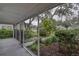 View of the inviting screened front porch showcasing the manicured front yard at 210 Palermo Pl, Lady Lake, FL 32159