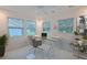 Bright home office featuring a sleek glass desk, modern chair, and large windows providing ample natural light at 210 Palermo Pl, Lady Lake, FL 32159