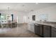 Open-concept kitchen and dining area with stainless steel dishwasher and stone countertops at 2184 Locklin Ln, The Villages, FL 32163