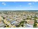 An aerial view of a neighborhood featuring lush greenery and well-maintained homes under a clear sky at 2495 Birch Ave, The Villages, FL 32162