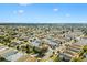 An aerial view of a house with blue awnings surrounded by other homes in a sunny neighborhood at 2495 Birch Ave, The Villages, FL 32162