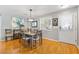 Chic dining area featuring a modern chandelier, hardwood floors and comfortable seating for four at 2495 Birch Ave, The Villages, FL 32162