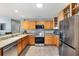 Bright kitchen with granite countertops, stainless steel appliances, and wood cabinets at 2495 Birch Ave, The Villages, FL 32162