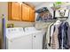 Bright laundry room with modern washer and dryer, overhead cabinets and extra storage at 2495 Birch Ave, The Villages, FL 32162