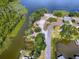 Aerial view of a community waterfront area with trees, a dock, a small beach, and lush vegetation at 26608 E Cove Dr, Tavares, FL 32778
