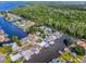 Scenic aerial view of a community nestled amid winding waterways, lush forests, and various waterfront homes at 26608 E Cove Dr, Tavares, FL 32778