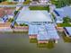 Aerial view of a waterfront home featuring a metal roof, dock, and covered boat lift in a residential area at 26608 E Cove Dr, Tavares, FL 32778