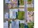 Aerial view of a waterfront property, showing the metal roof, lawn, driveway and boat lift and surrounding neighborhood at 26608 E Cove Dr, Tavares, FL 32778
