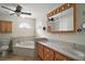 Well-lit bathroom featuring double sinks, a large tub, and a ceiling fan at 26608 E Cove Dr, Tavares, FL 32778