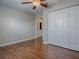 Bedroom with hardwood floors, ceiling fan, and white closet doors at 26608 E Cove Dr, Tavares, FL 32778
