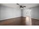 This bedroom is empty, with hardwood floors, a ceiling fan, and an entrance to another room at 26608 E Cove Dr, Tavares, FL 32778