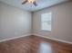 Bedroom with hardwood floors and a large window offering natural light at 26608 E Cove Dr, Tavares, FL 32778