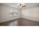 Bright bedroom featuring wood floors, a ceiling fan, and a large window for ample natural light at 26608 E Cove Dr, Tavares, FL 32778