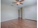 Bedroom with hardwood floors, ceiling fan, and white closet doors at 26608 E Cove Dr, Tavares, FL 32778